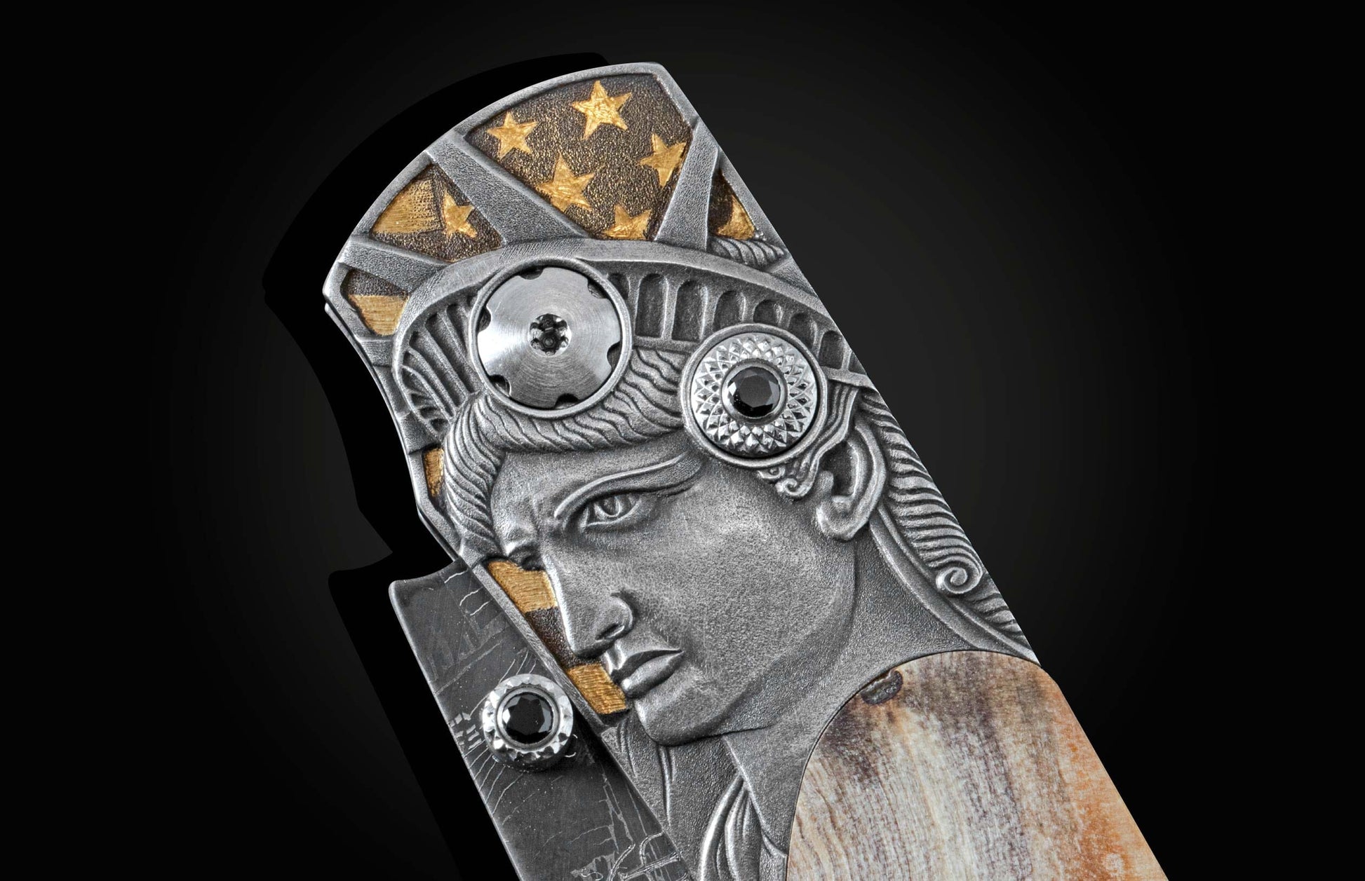 Handcrafted knife from William Henry features hand-engraved depictions of George Washington and the Statue of Liberty inlaid with a wood scale from trees planted by George Washington and set with spinel gemstones.. The blade is hand-forged damascus steel.