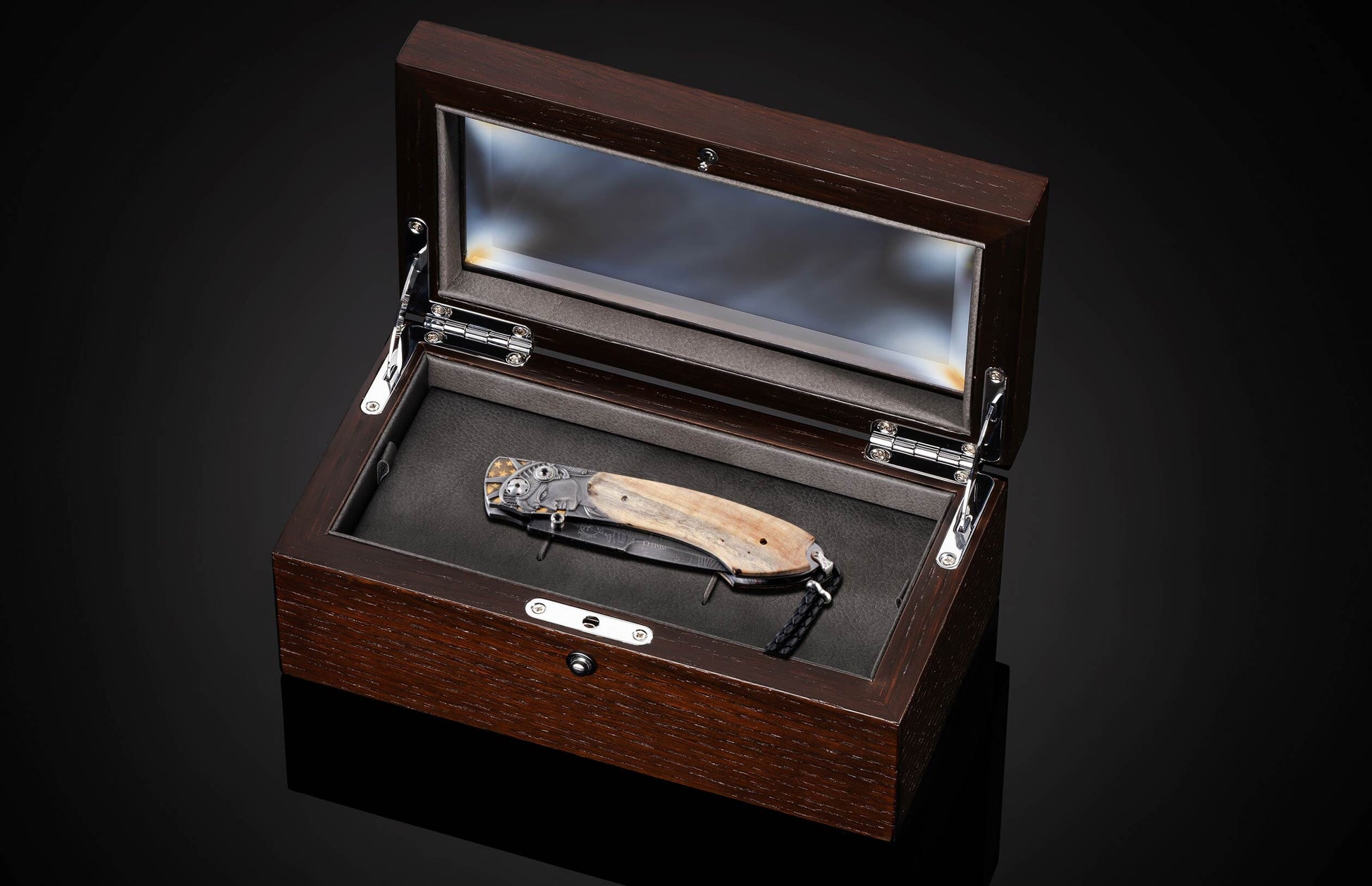 Handcrafted knife from William Henry features hand-engraved depictions of George Washington and the Statue of Liberty inlaid with a wood scale from trees planted by George Washington and set with spinel gemstones.. The blade is hand-forged damascus steel.