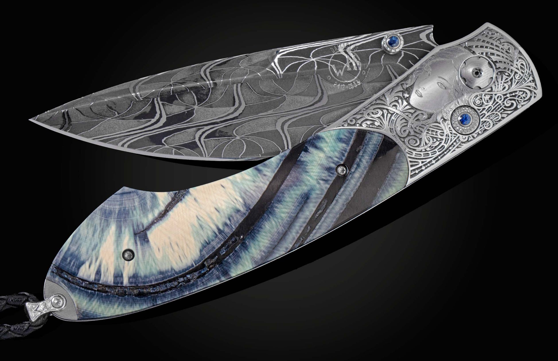 Handcrafted pocket knife from William Henry features a stainless steel frame, beautifully hand-engraved by Frederique Lepinois depicting a woman's face and intricate scrollwork inlayed with blue 10,000 year old ring cut fossil woolly mammoth tusk. The bla