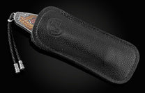 Handcrafted pocket knife from William Henry features beautiful color laser engraving of pirate scenes by Bottega Incisioni in Italy and set with spinel gemstones. The blade is damascus  steel.