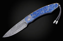 Custom William Henry knife featuring blue anodized titanium handle with high detail paisley design