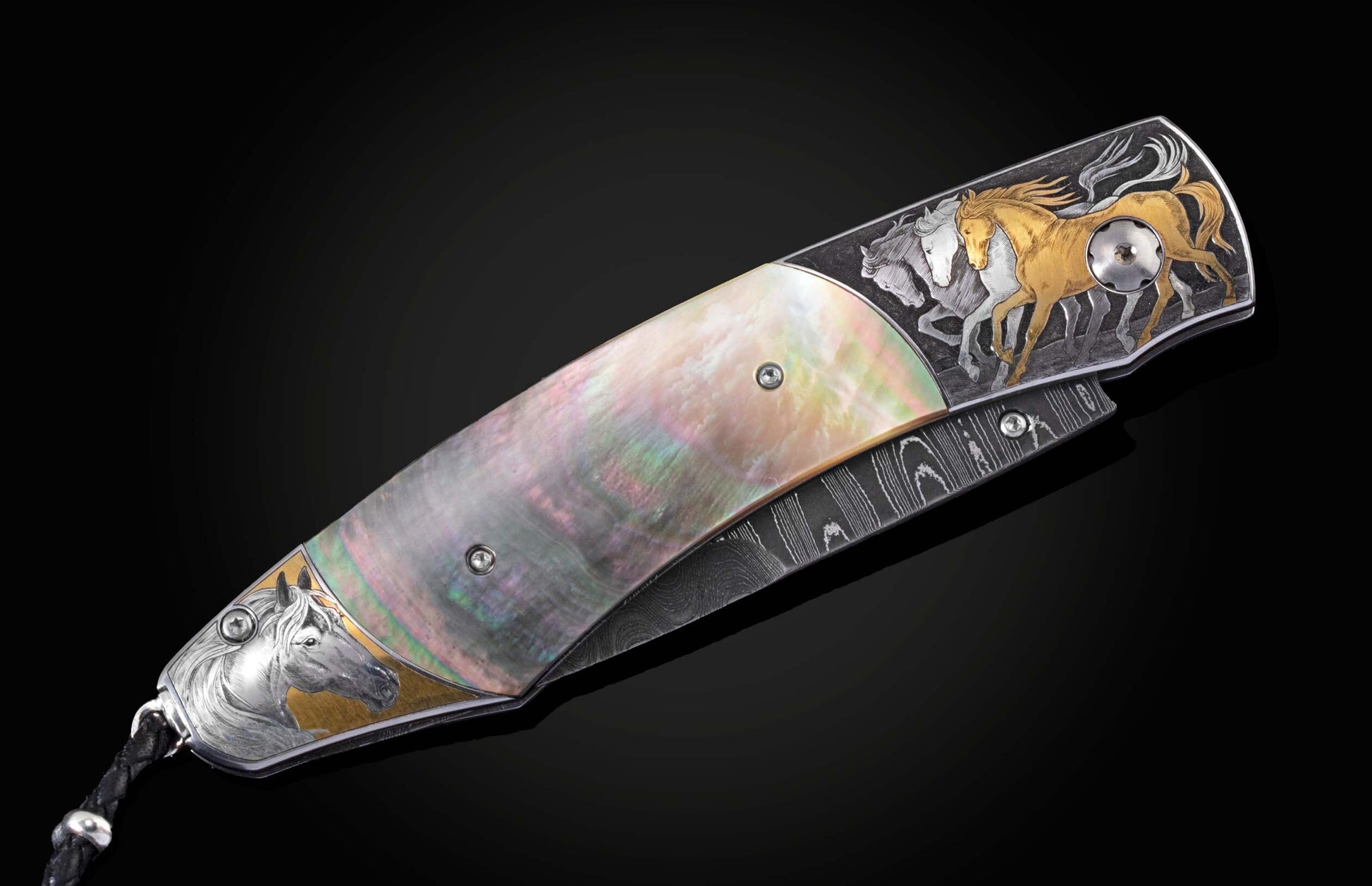 Handcrafted knife from William Henry featuring hand-engraved horses with 24K gold and silver inlays and scales of black lip pearl and stud are set with spinel gemstones. The Damascus steel blade is hand-forged with Gibeon Meteorite.