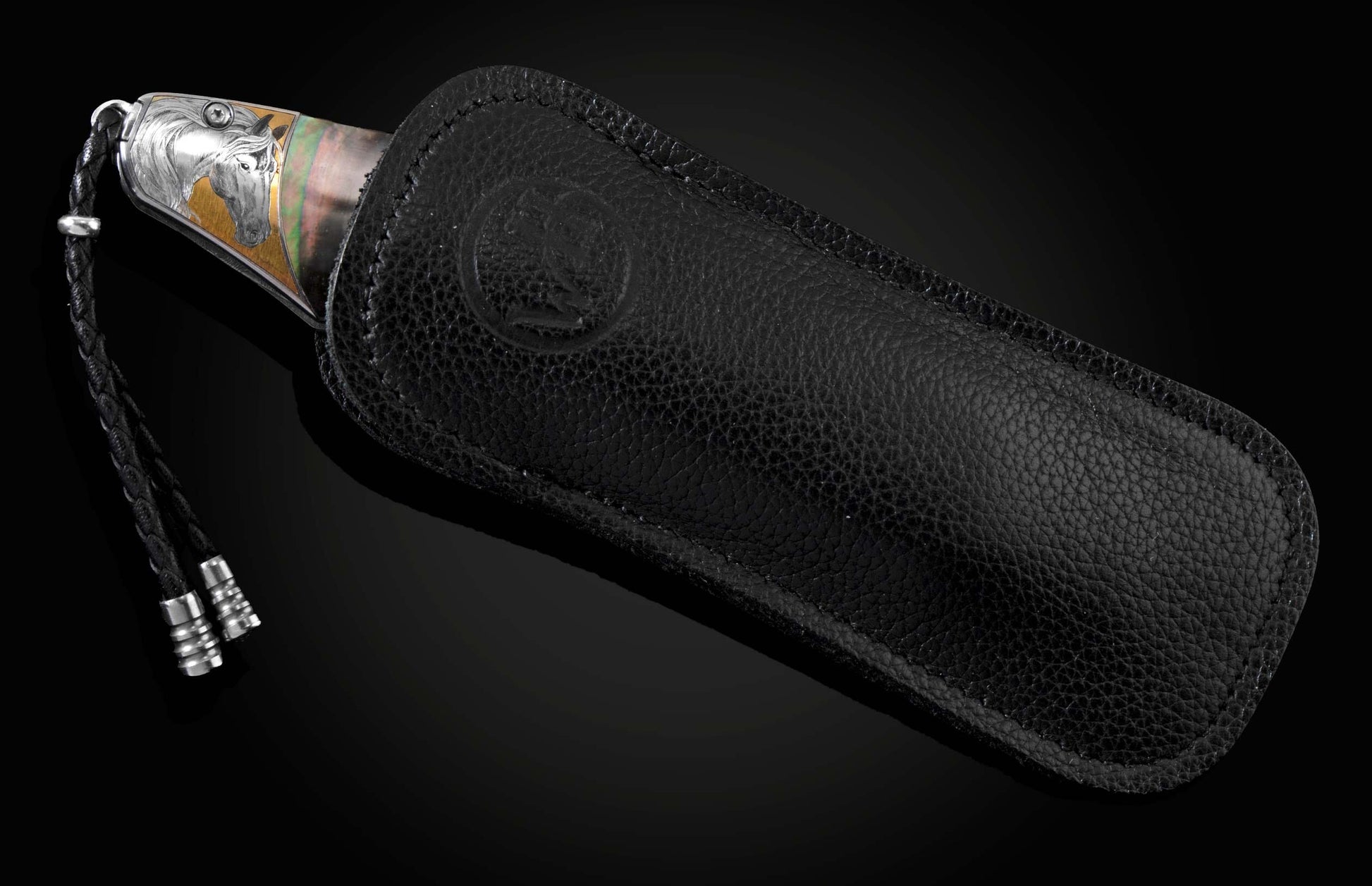 Handcrafted knife from William Henry featuring hand-engraved horses with 24K gold and silver inlays and scales of black lip pearl and stud are set with spinel gemstones. The Damascus steel blade is hand-forged with Gibeon Meteorite.