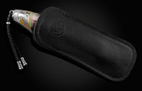 Handcrafted knife from William Henry featuring hand-engraved horses with 24K gold and silver inlays and scales of black lip pearl and stud are set with spinel gemstones. The Damascus steel blade is hand-forged with Gibeon Meteorite.