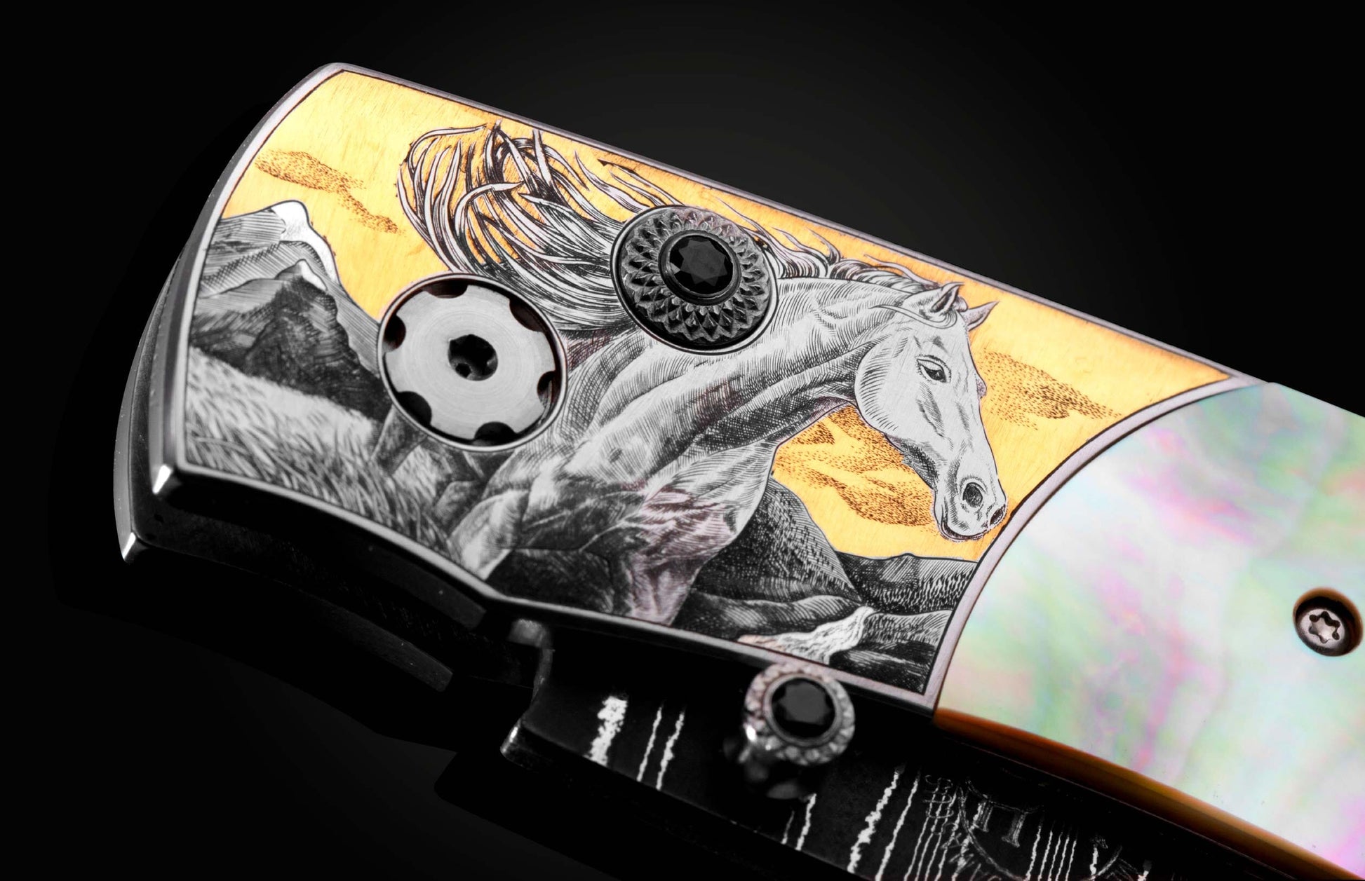 Handcrafted knife from William Henry featuring hand-engraved horses with 24K gold and silver inlays and scales of black lip pearl and stud are set with spinel gemstones. The Damascus steel blade is hand-forged with Gibeon Meteorite.
