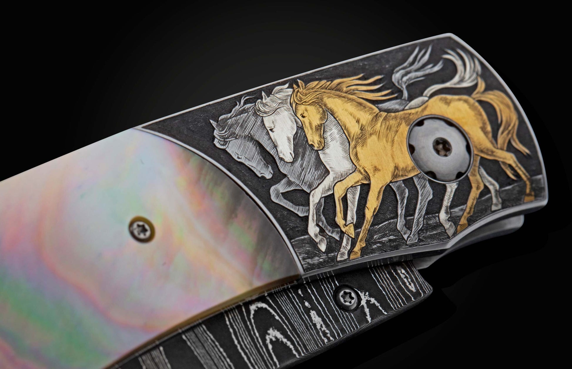 Handcrafted knife from William Henry featuring hand-engraved horses with 24K gold and silver inlays and scales of black lip pearl and stud are set with spinel gemstones. The Damascus steel blade is hand-forged with Gibeon Meteorite.