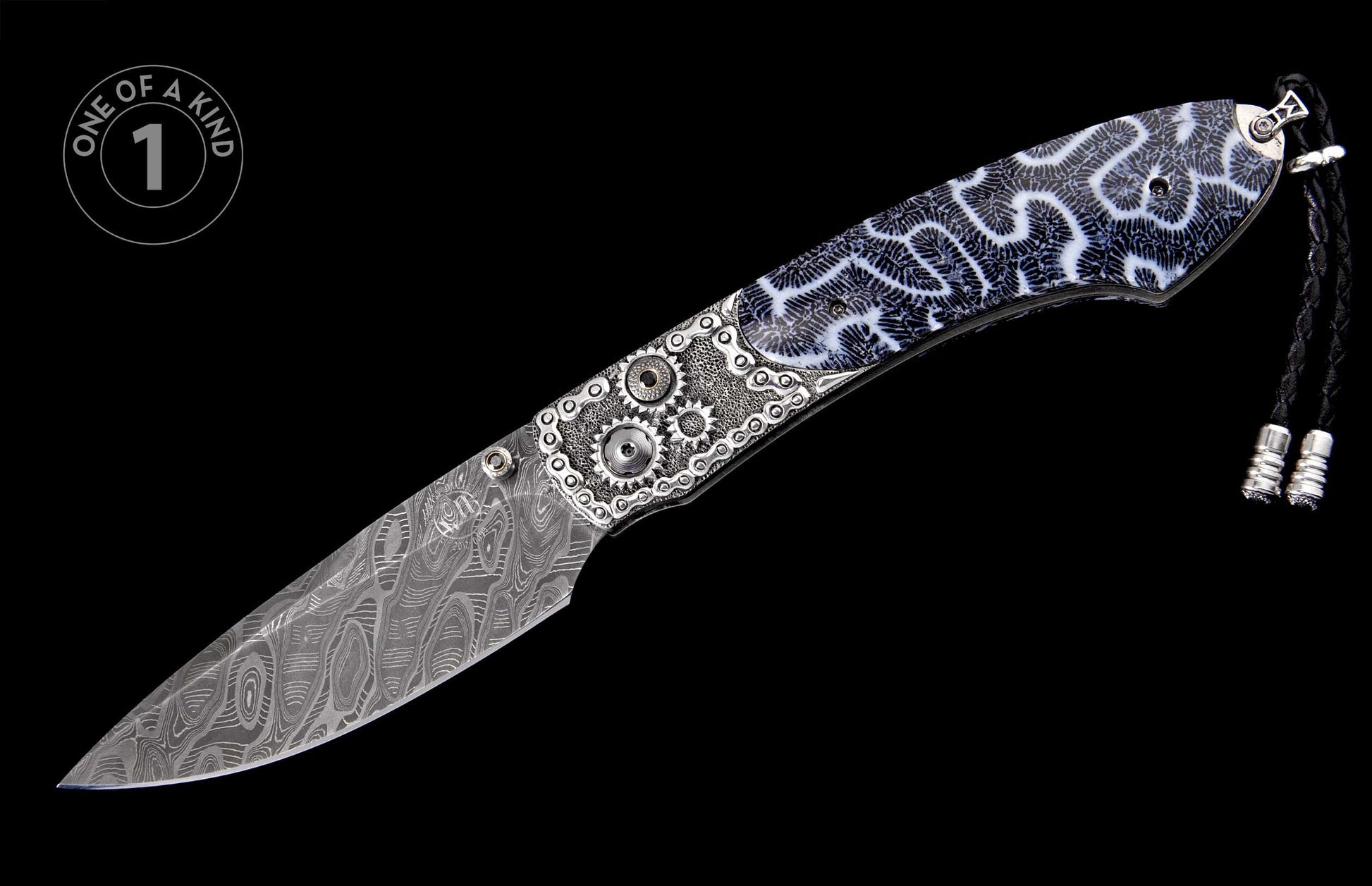 Knife with a wavy Damascus steel blade, intricate silver-toned gear and chain-link metalwork, black and white coral-patterned grip, and braided black lanyard.
