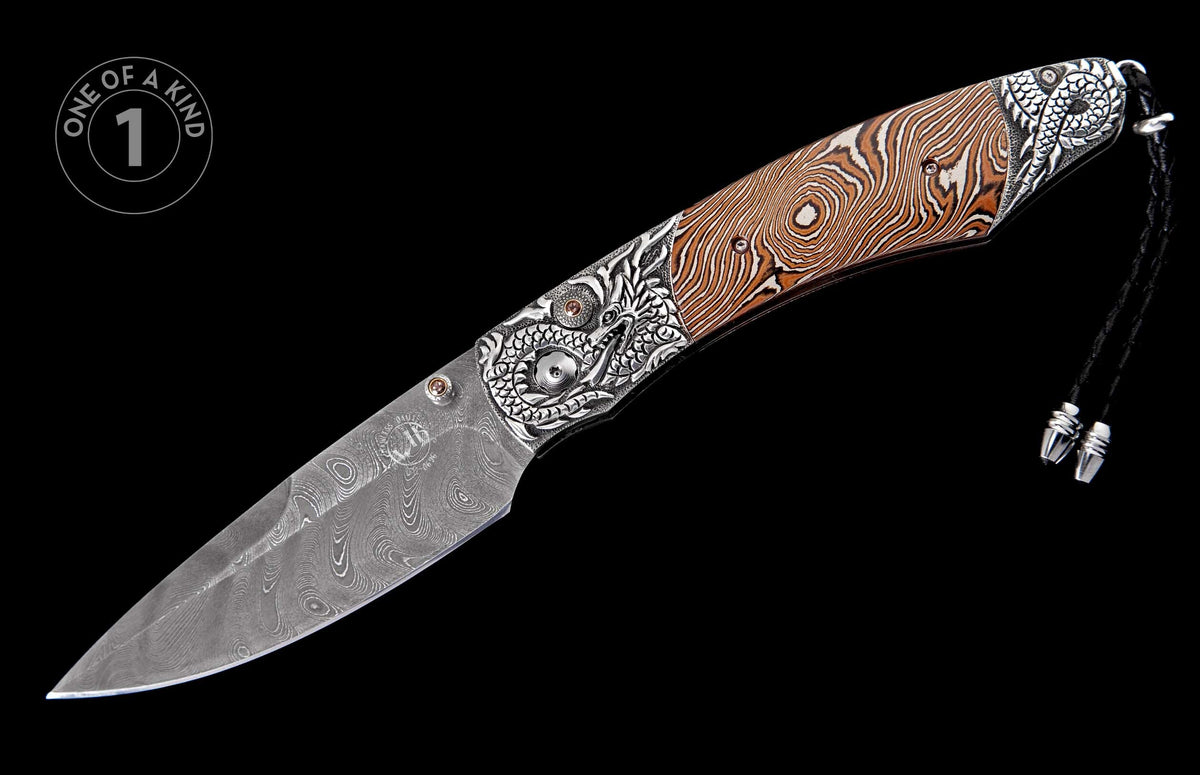 Ornate folding knife with a Damascus steel blade, brown and silver patterned handle, intricate dragon engravings, and a black lanyard.