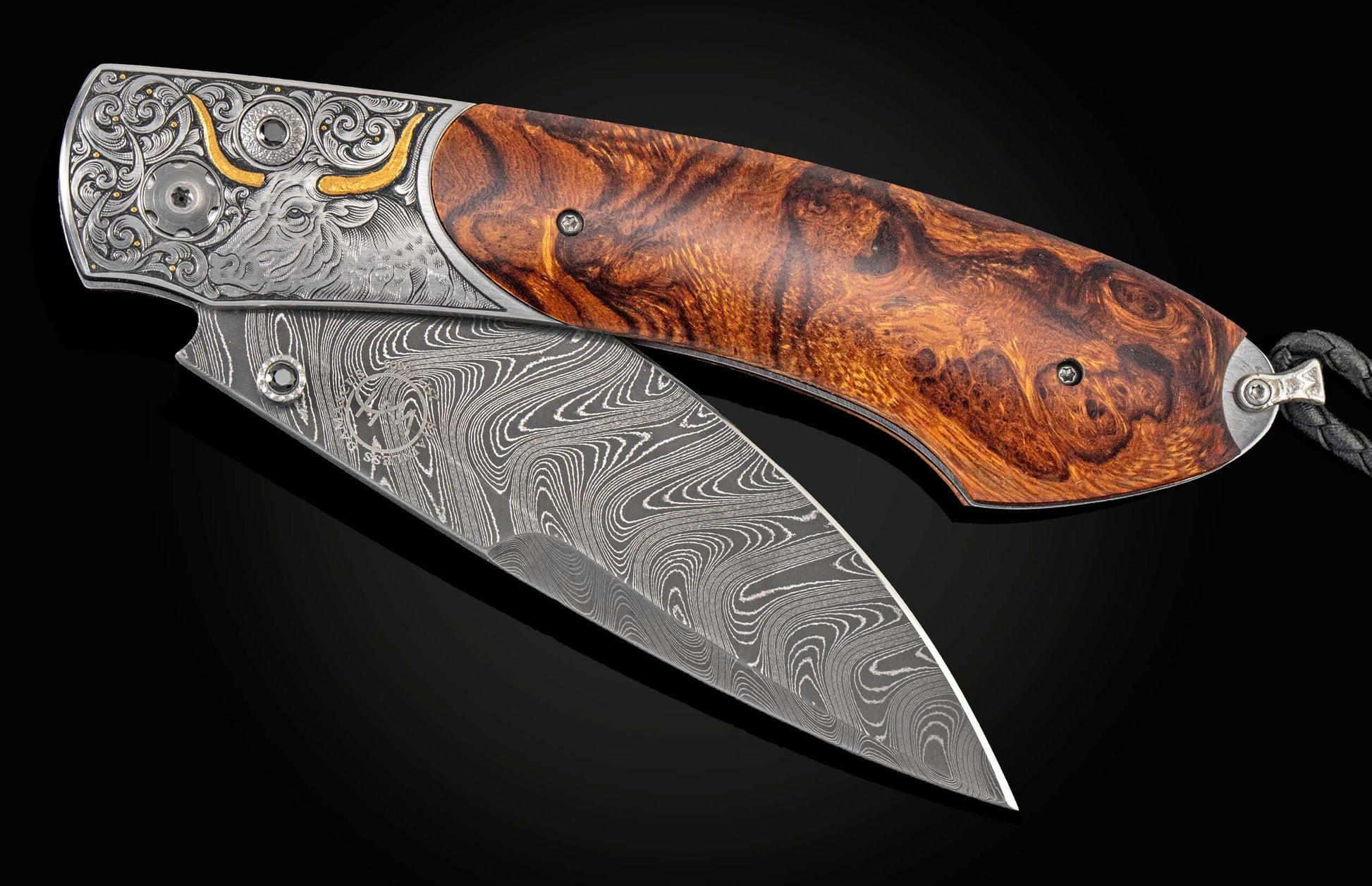 Handcrafted William Henry custom knife with hand-engraved frame with 24K gold inlays depicting a bull by Tyler Prince, inlaid with desert ironwood, spinel gemstones, and a hand forged Damascus steel blade by Chad Nichols