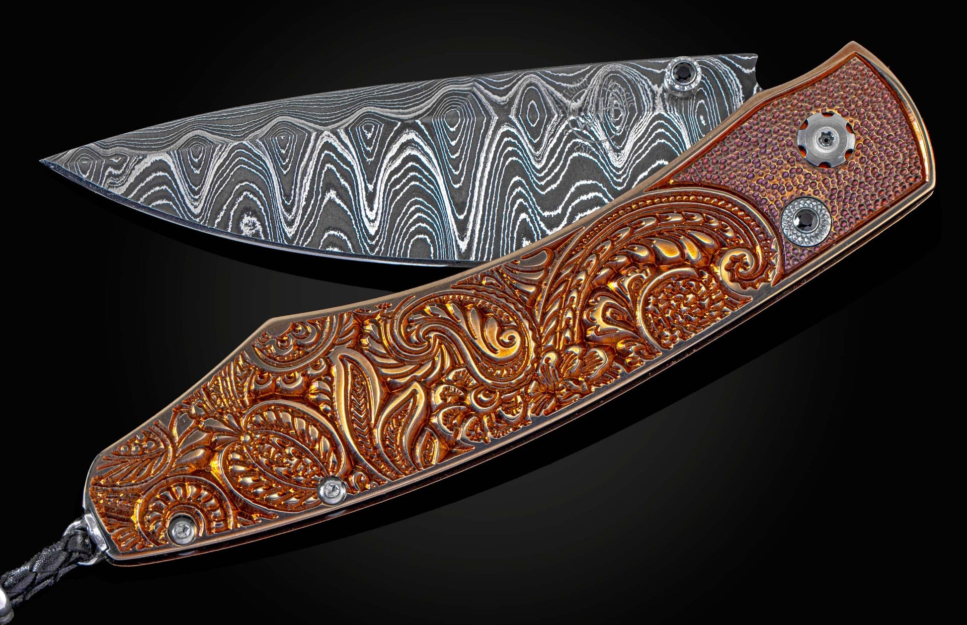 Handcrafted William Henry knife with high detail micro machined paisley pattern bronze titanium handle, spinel gemstones, and a damascus blade, hand-forged with Gibeon Meteorite by Chad Nichols