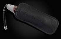 Handcrafted pocket knife from William Henry features a titanium frame inlaid with beautiful Black Palm wood and set with spinel gemstones and a hand forged Damascus steel blade.