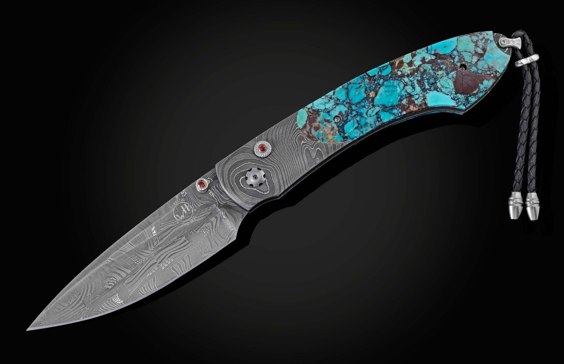 Handcrafted pocket knife from William Henry with a frame in hand-forged Damascus steel inlaid with black Matrix Kingman turquoise and set with garnets. The blade is hand forged damascus steel