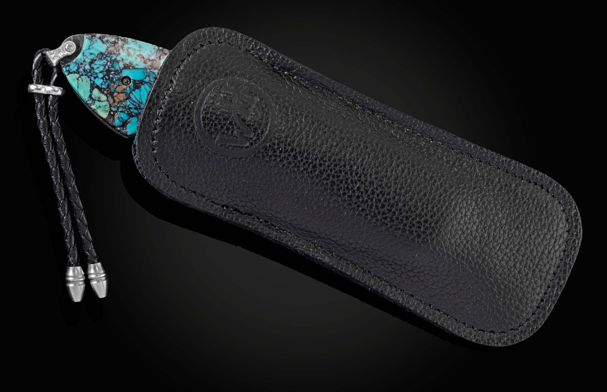 Handcrafted pocket knife from William Henry with a frame in hand-forged Damascus steel inlaid with black Matrix Kingman turquoise and set with garnets. The blade is hand forged damascus steel