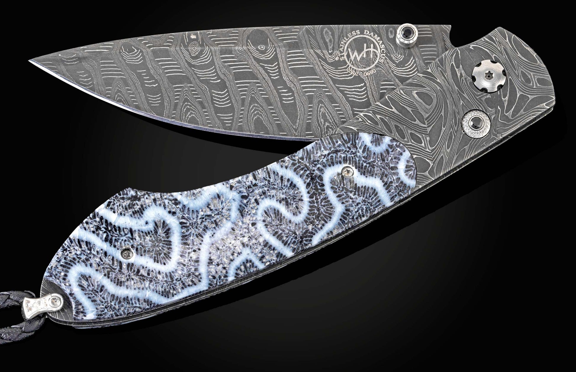 Handcrafted William Henry custom knife featuring fossil coral scales, a Damascus steel frame and blade, and spinel gemstones.