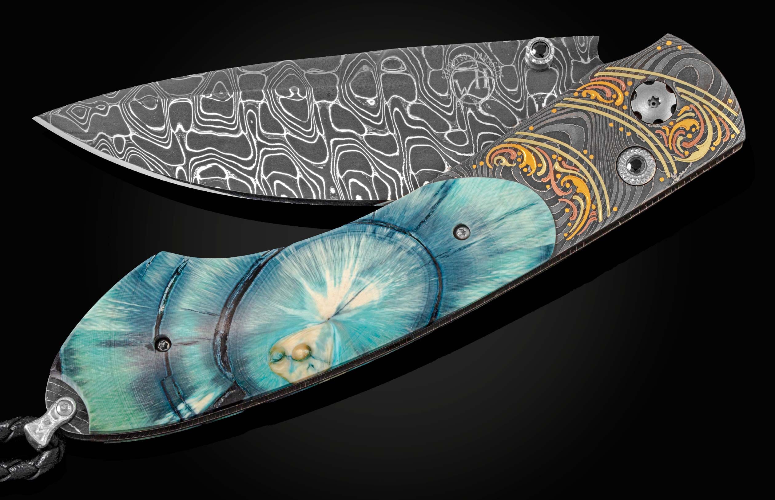 Hand crafted pocket knife from William Henry with a hand forged Damascus steel blade features hand-engraved bolsters with 22K and 24K yellow gold, 18K green gold, and copper inlays, inlaid with a brilliant blue ring-cut of 10,000 year-old fossil Woolly Ma