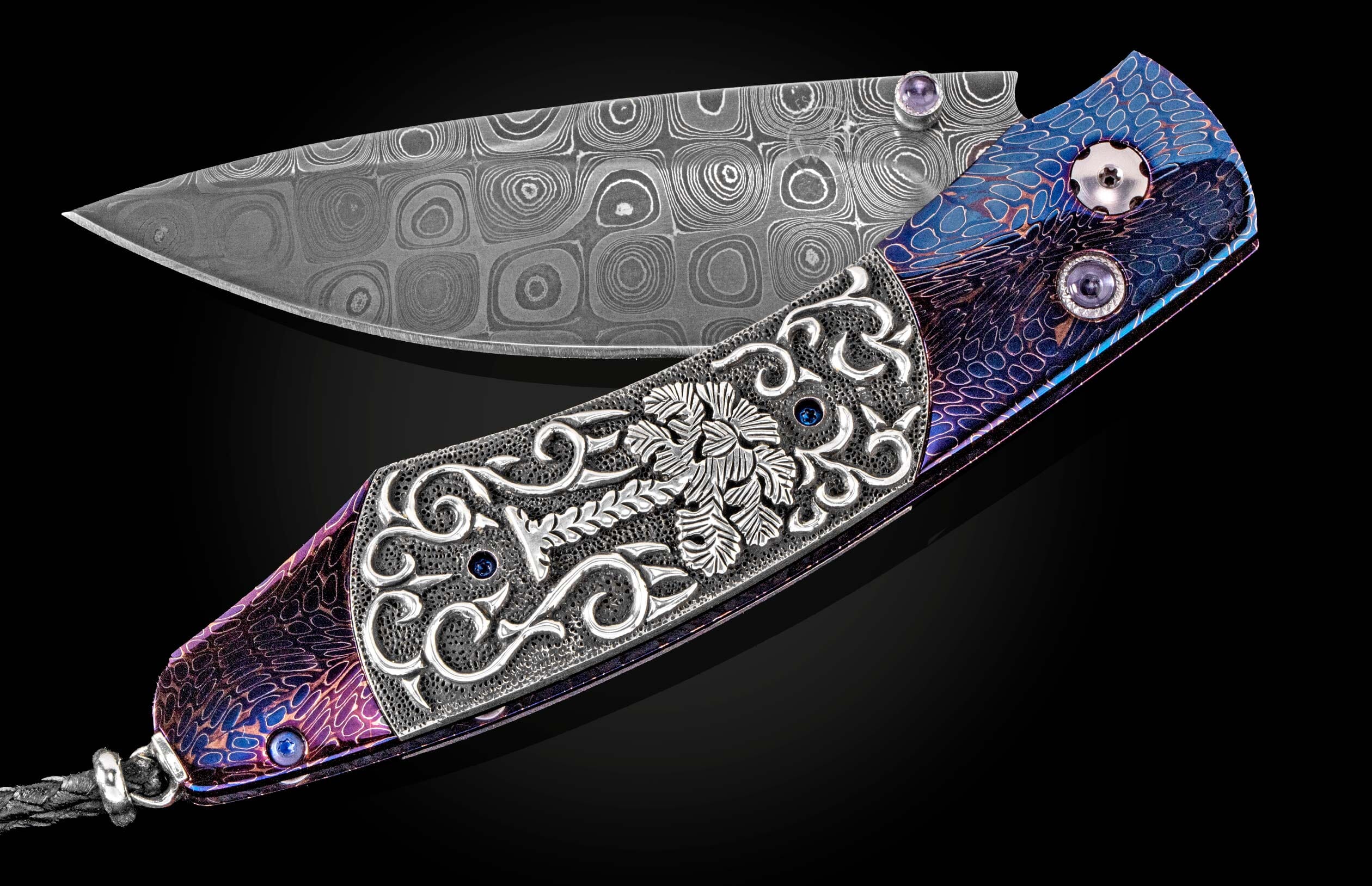 Ornate Damascus steel knife by SEWE featuring a purple and blue iridescent handle with intricate silver engraving, gemstone accents, and a braided leather lanyard, shown open.