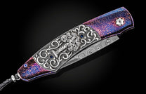 Folding knife by SEWE with ornate silver engraving, blue sapphires, vibrant purple handle, Damascus steel blade, and black lanyard.