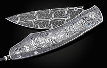 Silver-toned folding knife with a dark gray patterned blade and a steampunk-engraved handle featuring gears, clocks, an owl-like creature, and blue sapphire accents.