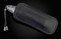 Engraved silver-toned folding knife partially sheathed in black pebbled leather with an embossed logo and braided lanyard.