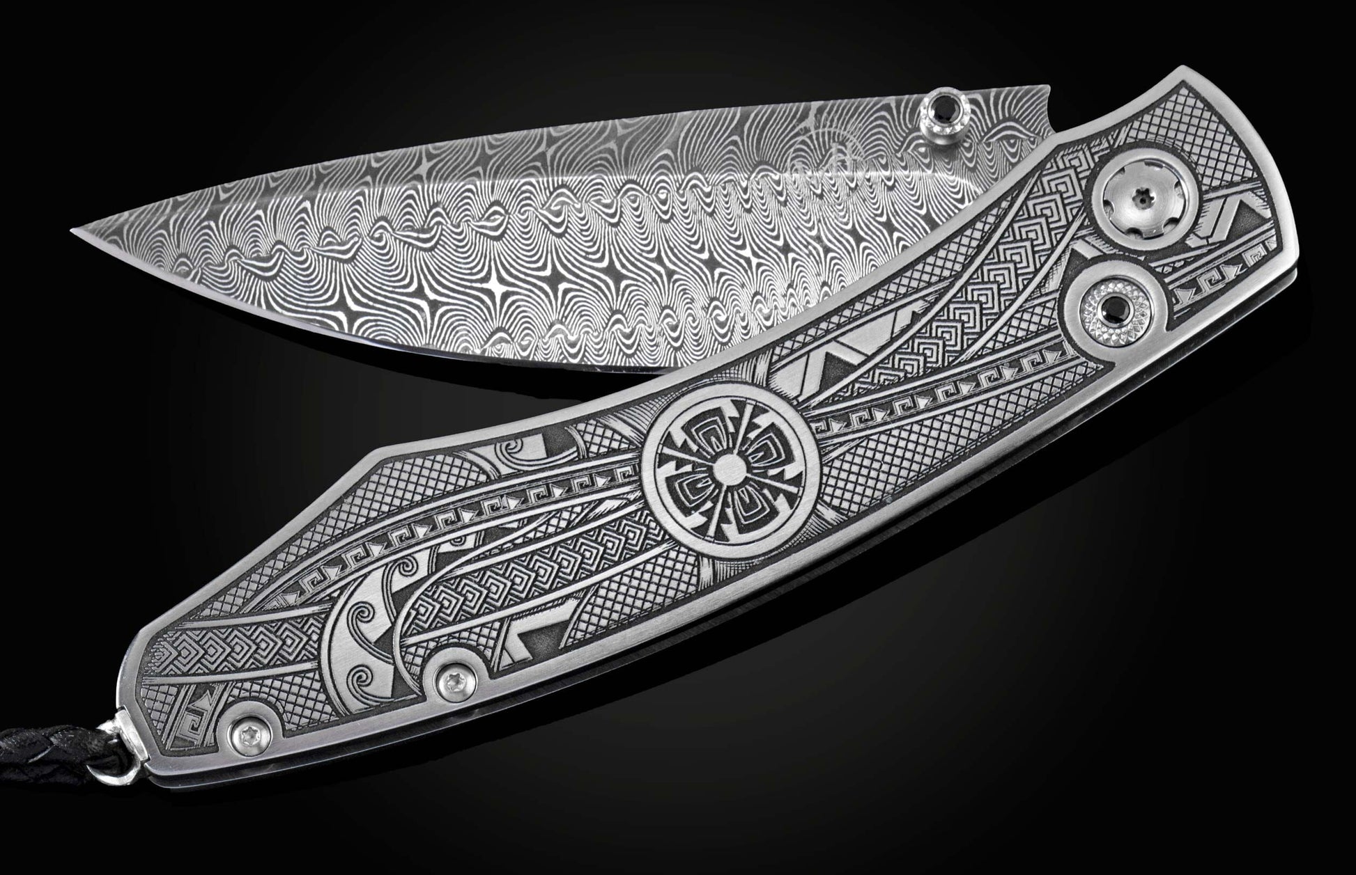 Handcrafted pocket knife from William Henry featuring an engraved tribal motif, a hand-forged Damascus steel blade, and spinel gemstones.