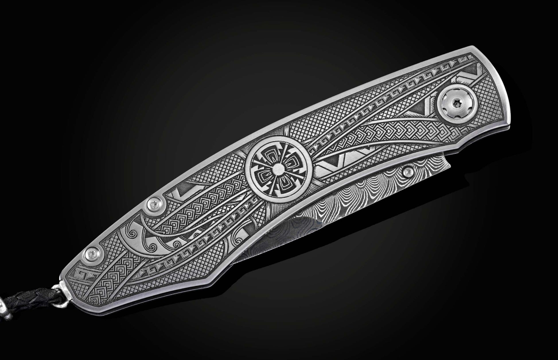 Handcrafted pocket knife from William Henry featuring an engraved tribal motif