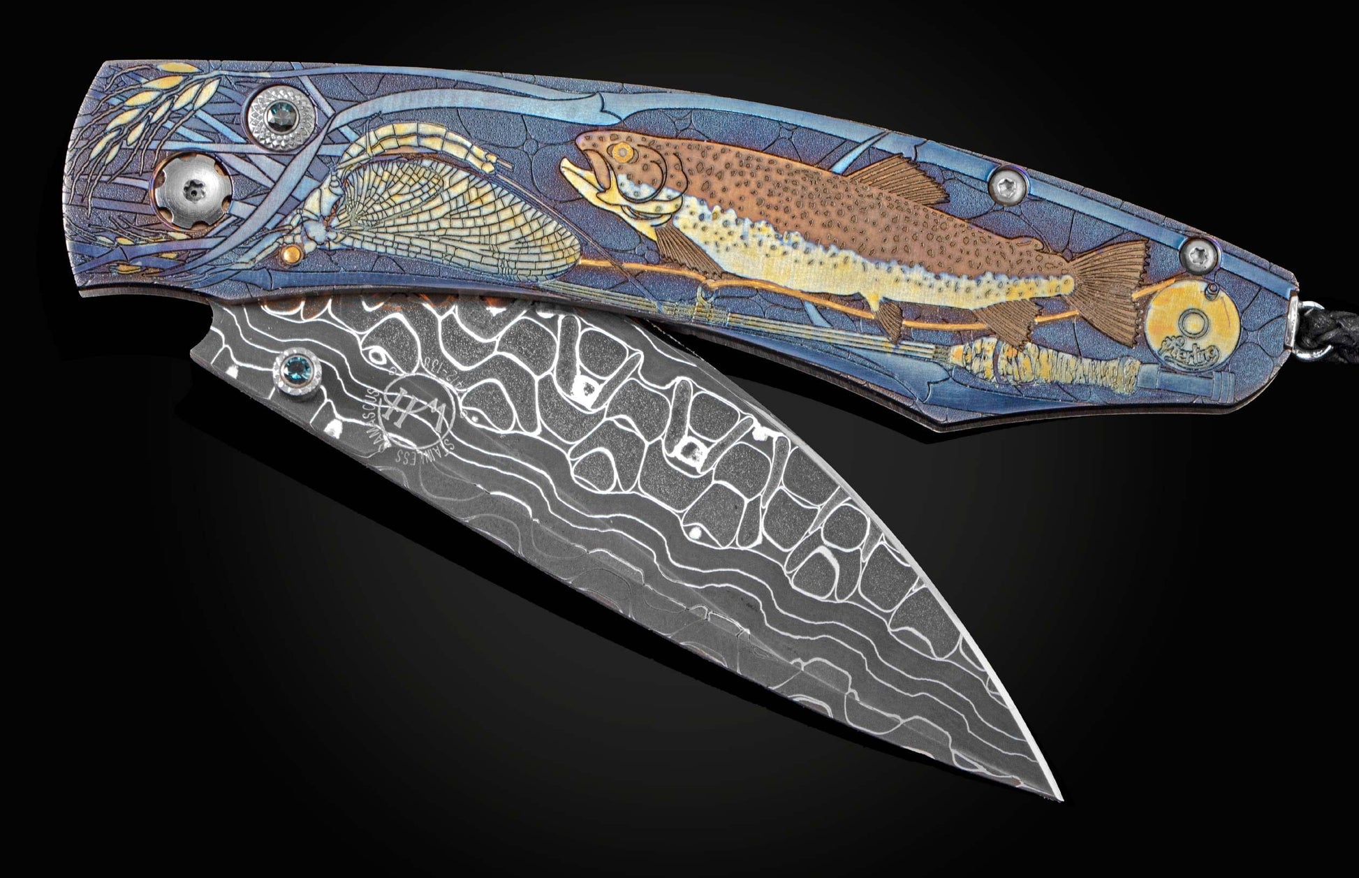 Unique pocket knife from William Henry, featuring hand-engraved and multi-layered laser engraved titanium, with inlaid 24K gold depicting a trout and fly fishing gear. The blade is hand-forged Damascus Steel and the button lock and the thumb stud are set 