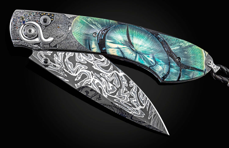 Handcrafted William Henry knife with hand-engraved image of  woolly mammoth, with 24K & 23K gold, silver, copper, and sapphires by Marcus Evans, and inlaid fossil Woolly Mammoth tusk, spinel gemstones and hand forged damascus steel blade by Luke Mattern