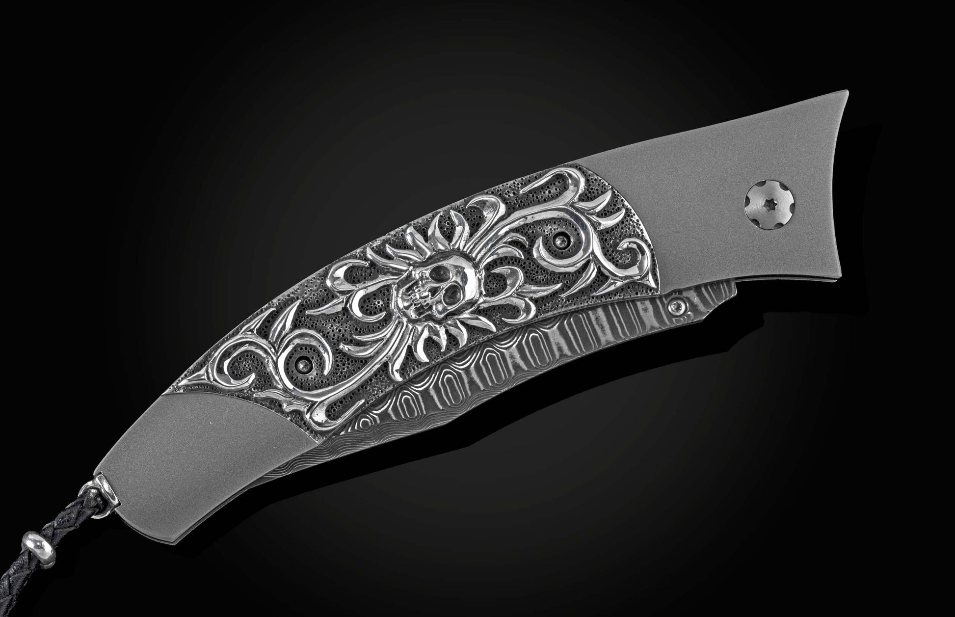Handcrafted titanium pocket knife from William Henry inlaid with hand-carved sterling silver skull by Lee Downey