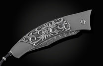 Handcrafted titanium pocket knife from William Henry inlaid with hand-carved sterling silver skull by Lee Downey