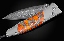 Handcrafted William Henry knife with titanium frame, inlaid with ' Zinc Matrix' apple coral, set with spinel gemstones, and a hand-forged damascus  steel blade.
