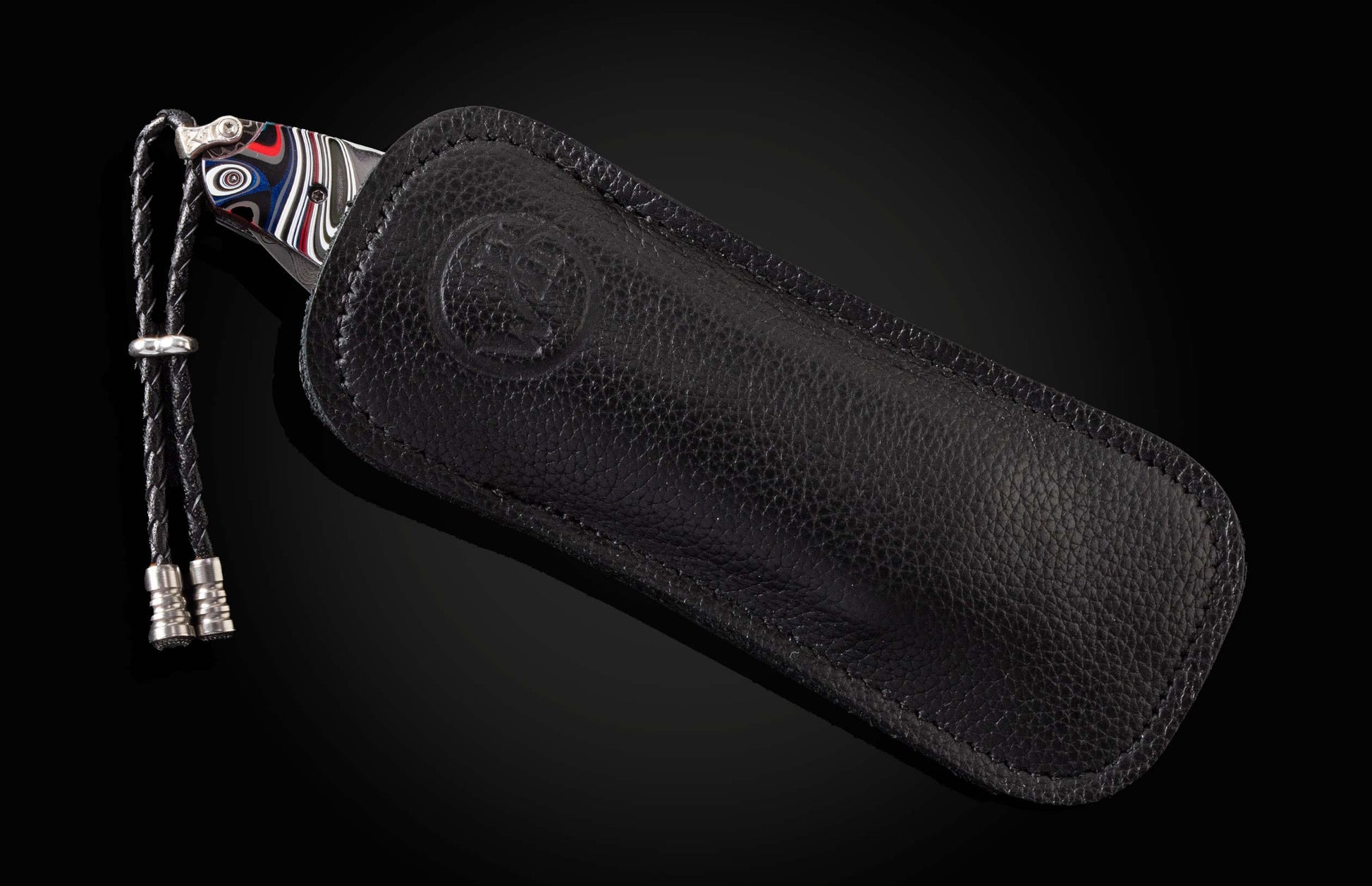 The Flathead Damascus Pocket Knife with Fordite Scales in a leather case