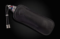 The Flathead Damascus Pocket Knife with Fordite Scales in a leather case