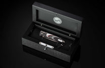 The Flathead Damascus Pocket Knife with Fordite Scales in a case