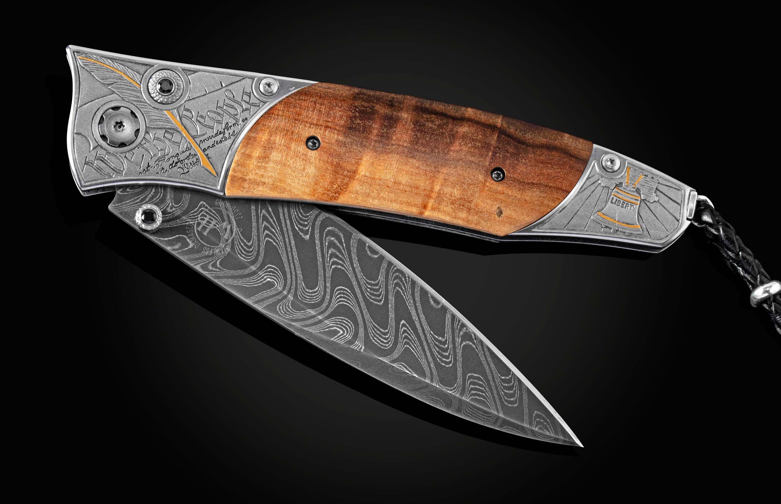 Open folding knife with a wavy Damascus steel blade, dark wood handle, and engraved silver bolsters featuring a golden feather and Liberty Bell.