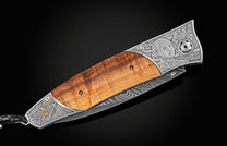 Folding knife with a natural wood handle, engraved George Washington, an eagle, and a Damascus steel blade.