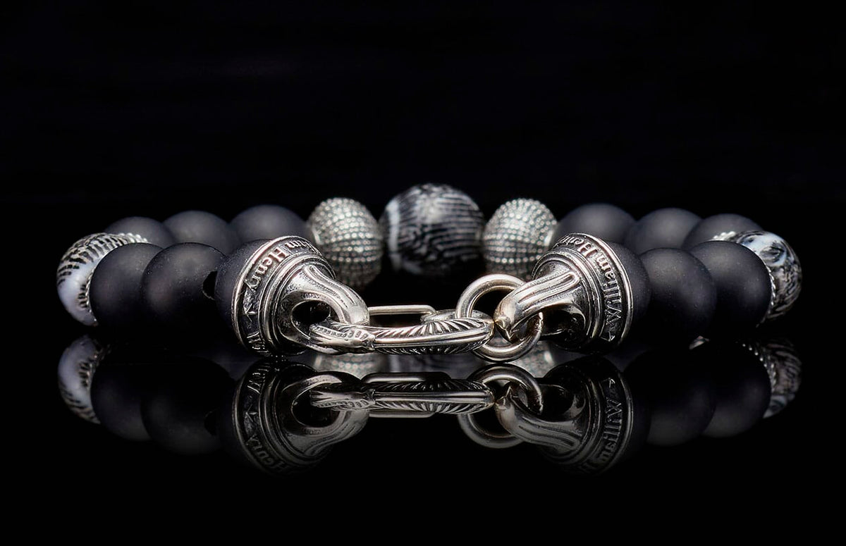 Freediver bracelet with matte black beads, silver textured and marbled accent beads, and a polished silver clasp engraved with 'William Henry'.