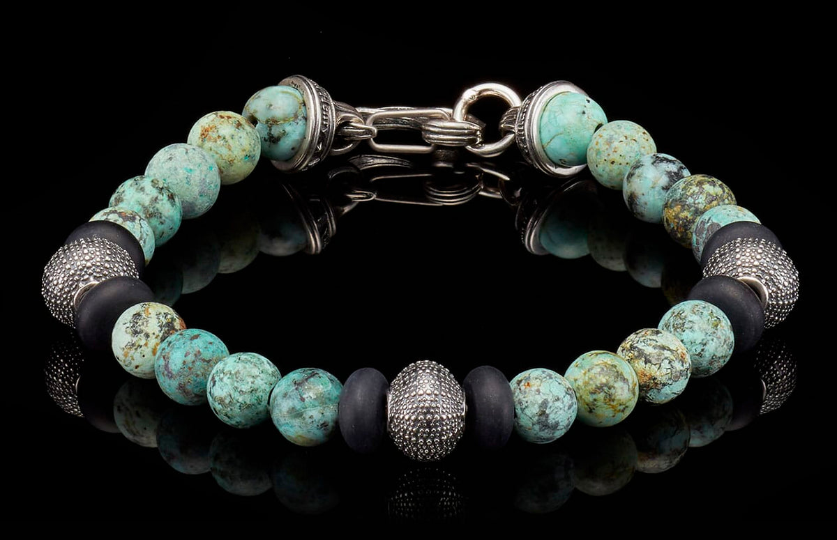 Beaded bracelet with marbled turquoise, matte black, and textured silver beads, featuring a silver toggle clasp.