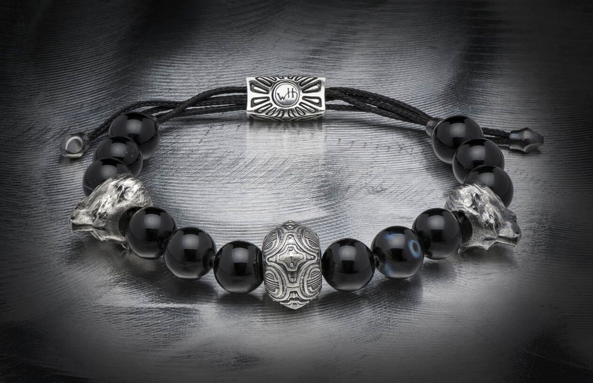 Black beaded bracelet featuring silver lion head beads, a central ornate silver bead, and a rectangular clasp with 'WTH' engraving.