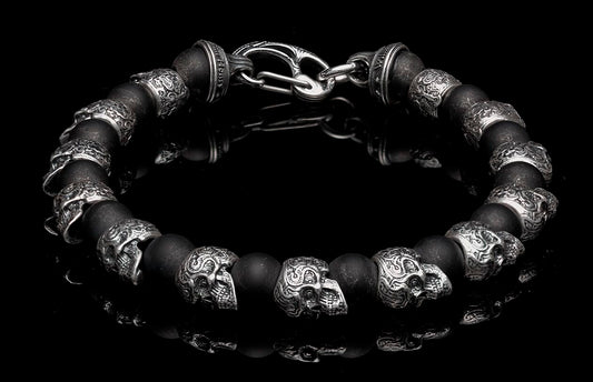 Black matte beaded bracelet with silver ornate skull charms and a hook clasp.