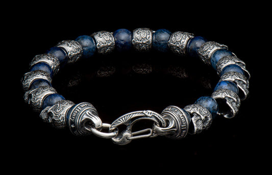 Dark blue beaded bracelet with intricate carved silver beads, a unique clasp, and 'William Henry' inscribed barrel bead.