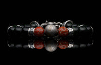 Handcrafted William Henry men's bracelet with dinosaur bone and shimmering green goldstone beads surround a singular Gibeon meteorite bead