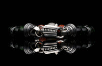 Handcrafted William Henry men's bracelet with dinosaur bone and shimmering green goldstone beads surround a singular Gibeon meteorite bead
