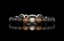 Beaded bracelet with meteorite, dinosaur bone, silver and onyx beads on a dark background