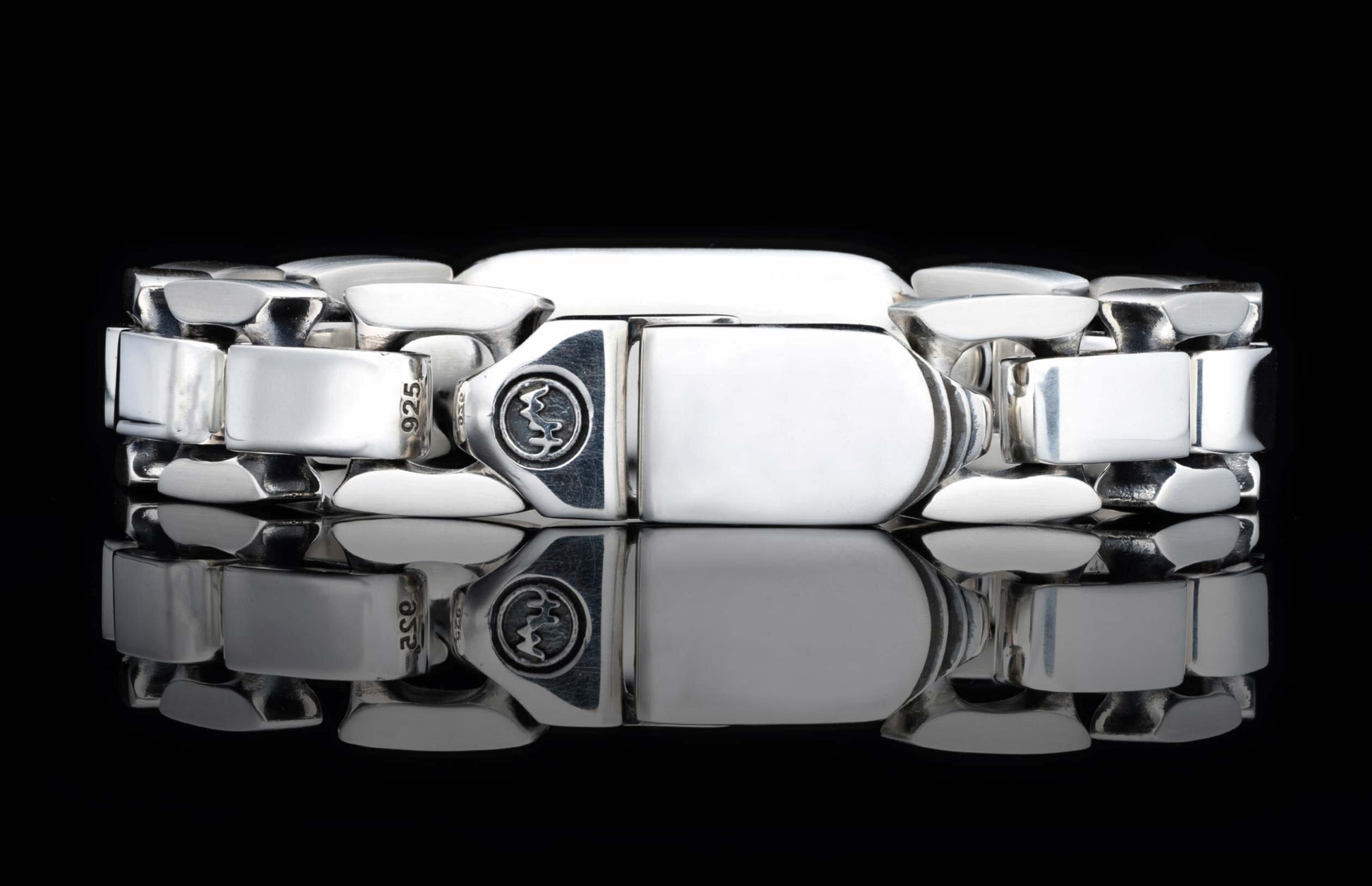 Polished sterling silver link bracelet with interlocking rectangular links, a decorative clasp emblem, and '925' stamp.