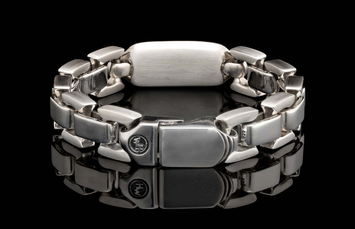 Silver-toned metal bracelet with chunky rectangular links, featuring a '925' hallmark and circular logo on the clasp.