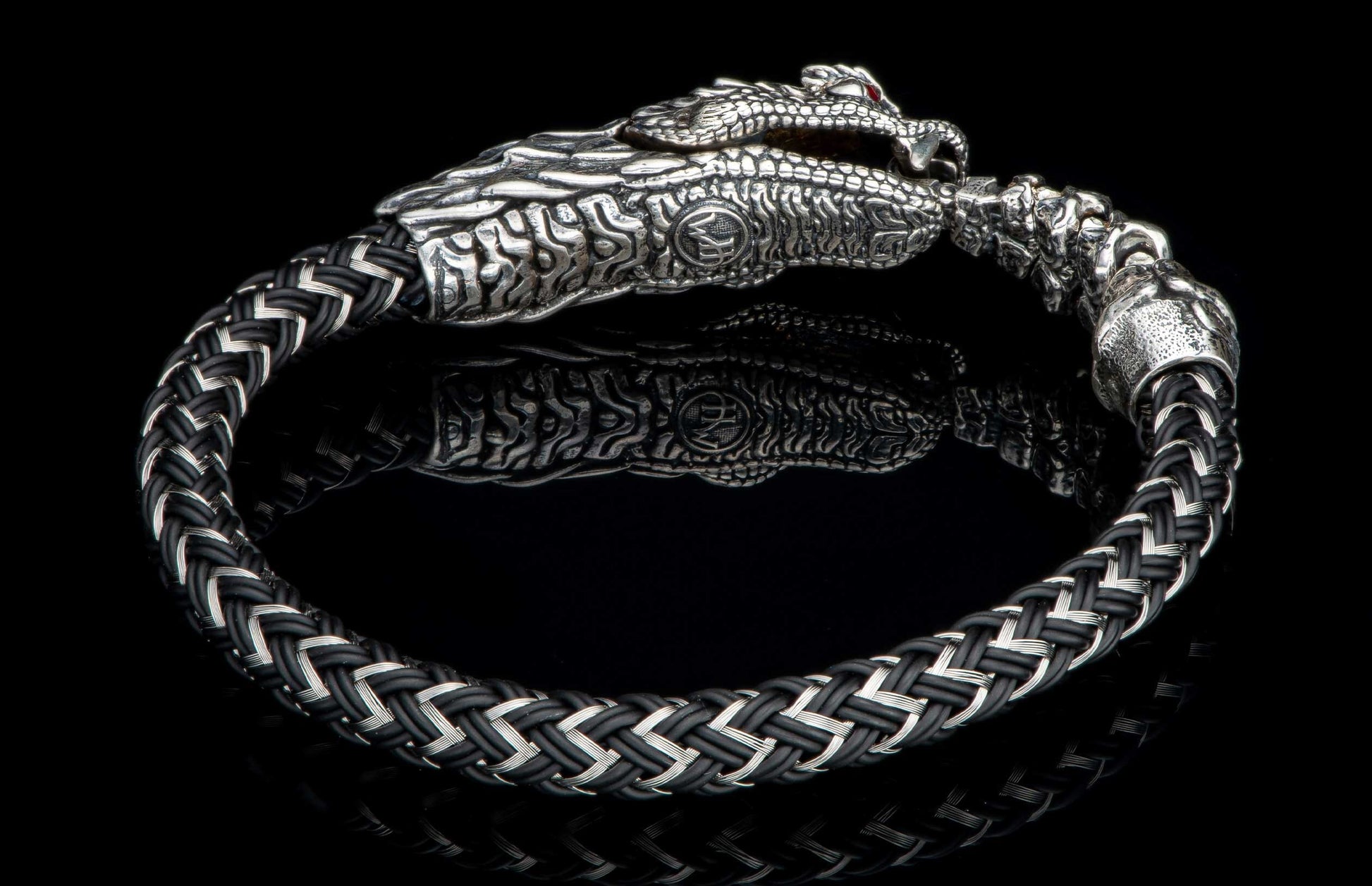 Black and silver braided bracelet with a detailed dragon head clasp, red eyes, and a reflective surface.