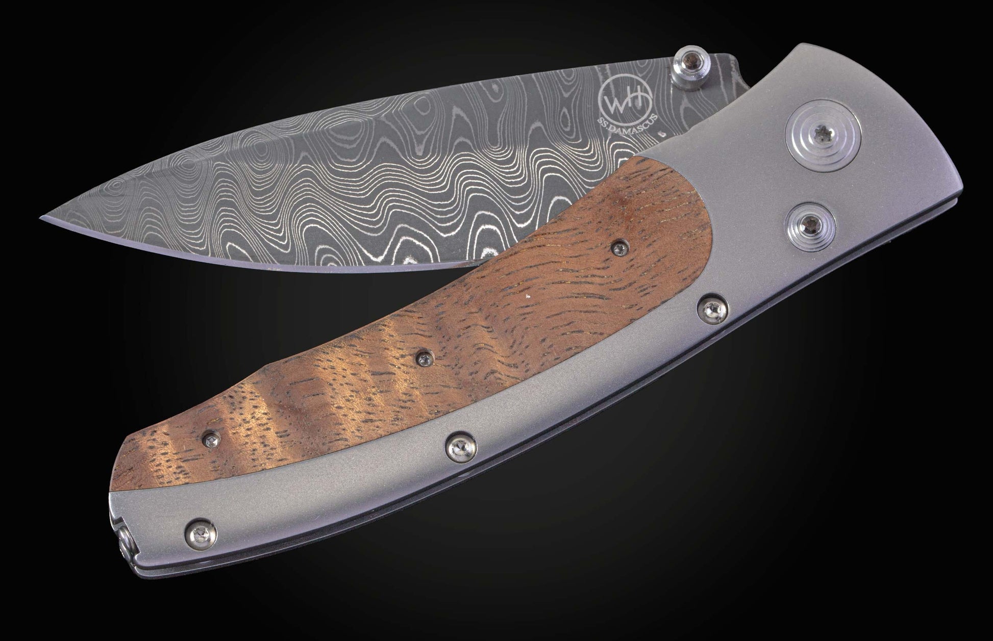 Handcrafted William Henry knife with Curly Koa wood set into a titanium frame, with a hand-forged damascus steel blade by Chad Nichols. 