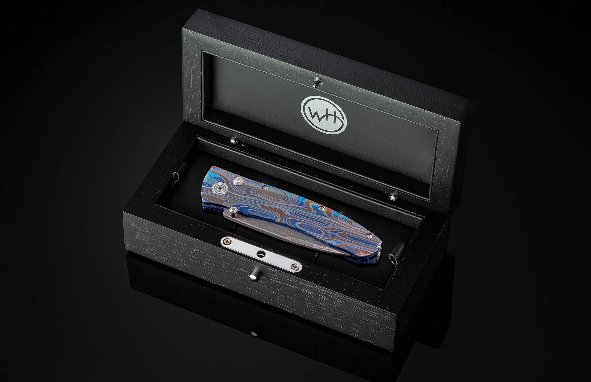 Handcrafted pocket knife from William Henry with a titanium frame that is anodized blue