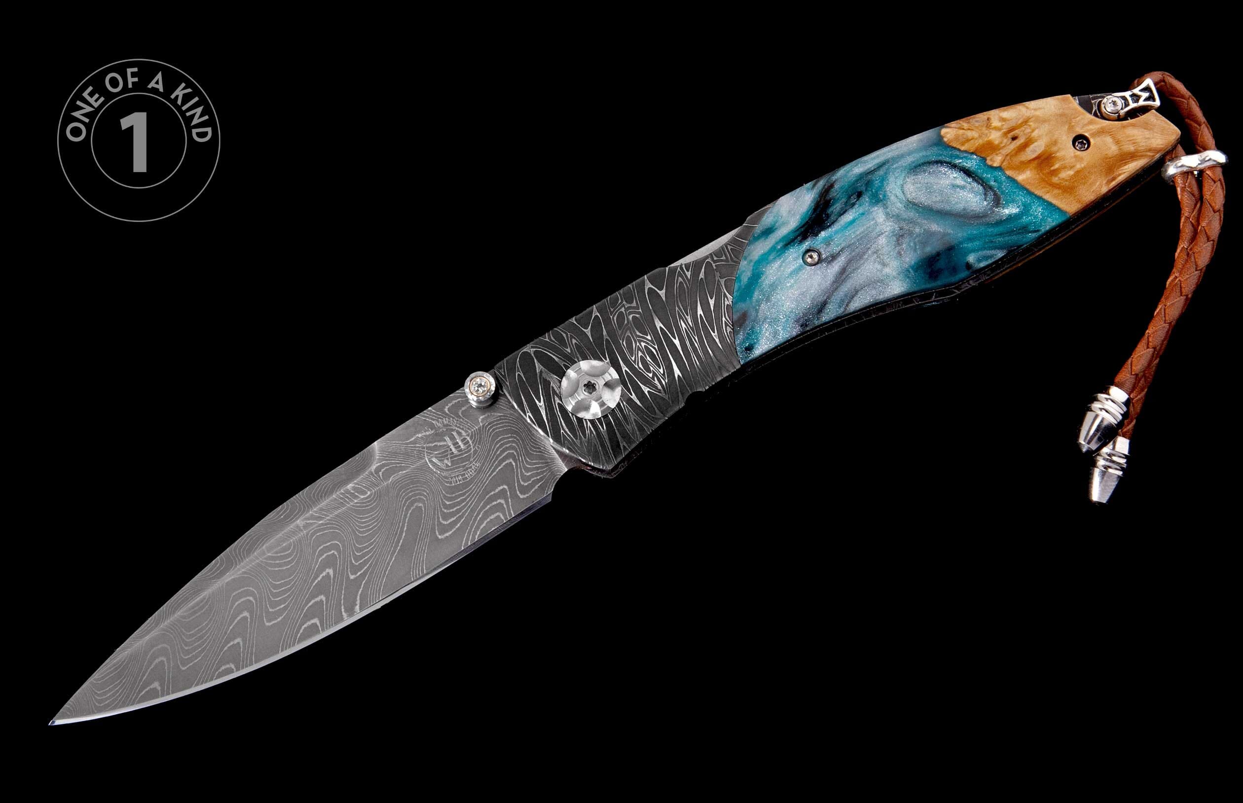 A one-of-a-kind folding knife featuring a patterned Damascus blade, a handle of blue resin with light wood, and a brown braided leather lanyard.