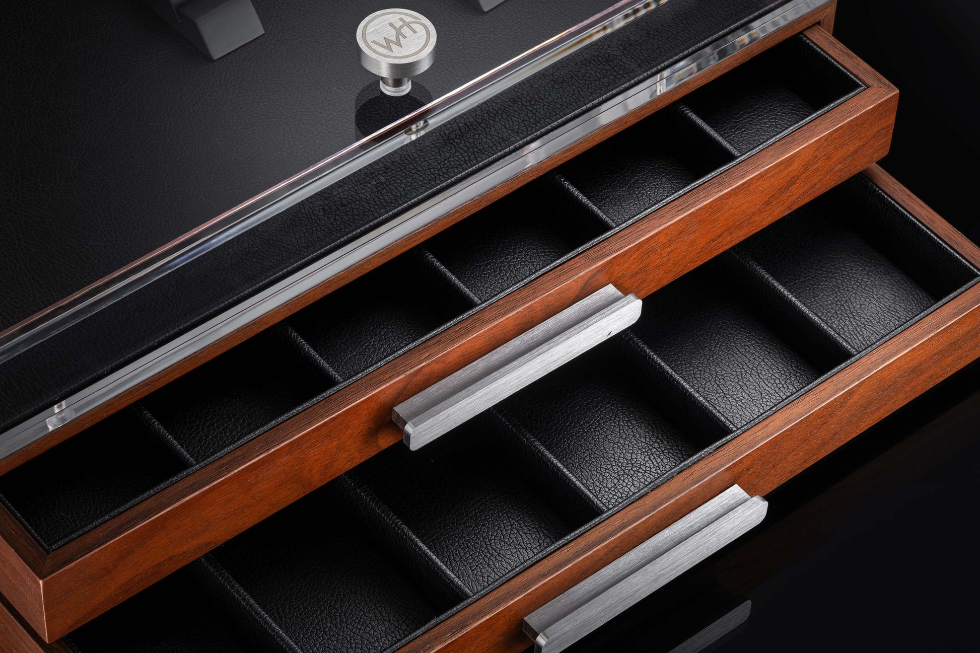 Wooden watch display case with black interior compartments on a dark background